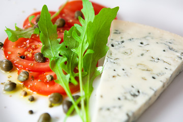 Tomato salad with arugula and a slice of gorgonzola