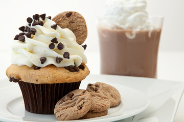 A Chocolate Chip Cookie Cupcake With Hot Chocolate In The Backgr