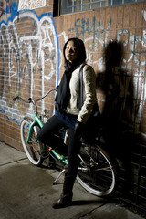Fototapeta na wymiar night street: young woman with the bike