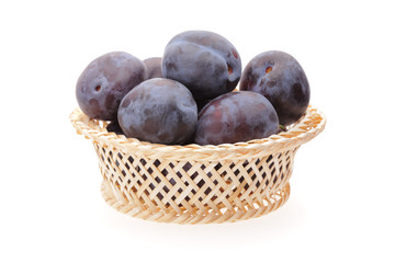 plums in basket on white background