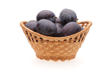 plums in basket on white background