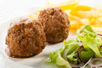 Roasted meatballs, fries and vegetable salad