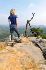 Frau steht auf Felsen im Elbsandsteingebirge