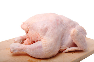 crude chicken on chopping board. It is isolated.