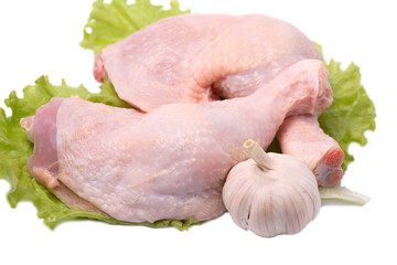 Crude chicken legs lie on salad leaves