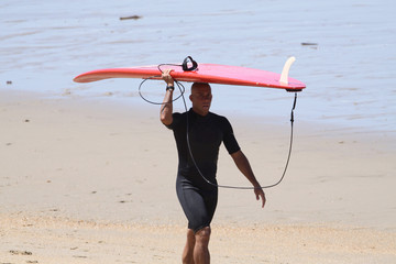 jeune homme en train de marcher sur la plage