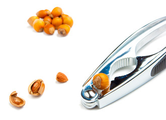Hazelnuts and nutcracker isolated on white