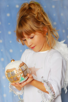 angel girl holding christmas ball in hand