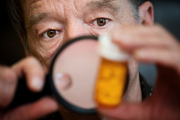 Man examining instructions on medicine bottle