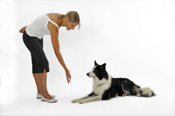 jeune femme apprenant à son chien à rester allongé