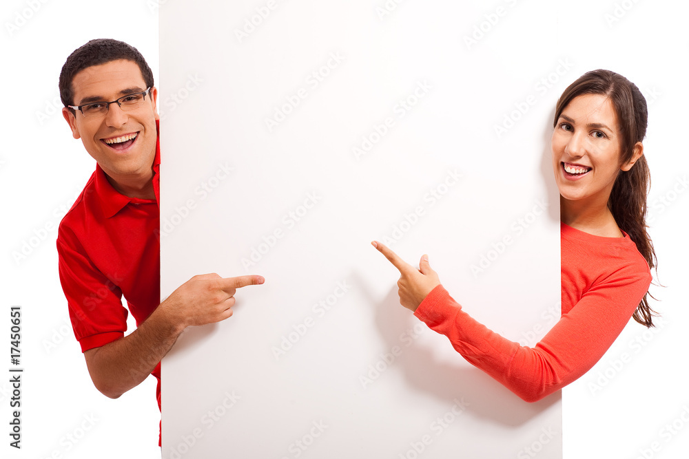 Wall mural happy young couple pointing to copy space