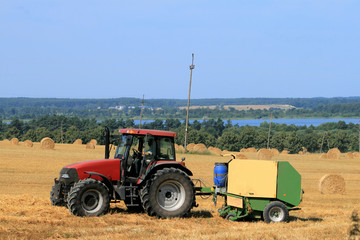 Landscape with tractor, straw bales and a lake