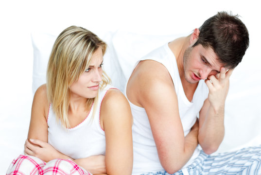 Angry couple having an argument in bed