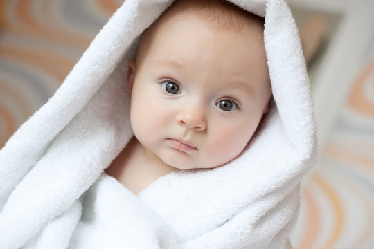 Portrait of a lovely baby covered with white towel