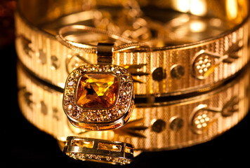 Golden bracelet and jewelry on dark background