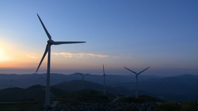 Wind turbine generator in the mountains at sunset