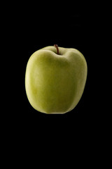 Green apple on black background