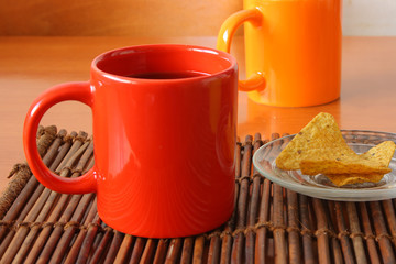 Red mug and chips on glass plate