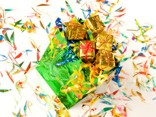 Bag full of small golden gifts around confetti. Shallow DOF.
