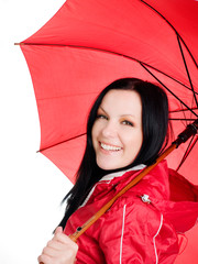 smiling brunette woman in fall clothes holding umbrella