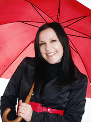 smiling brunette woman in fall clothes holding umbrel