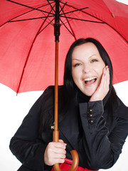 smiling brunette woman in fall, rainproof clothes holding umbrel