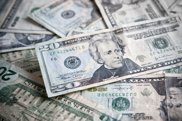 Pile of paper currency with Focus on the $20