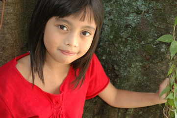 little girl stand up beside the tree