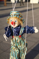 Toy clown with red nose. Puppet on a string