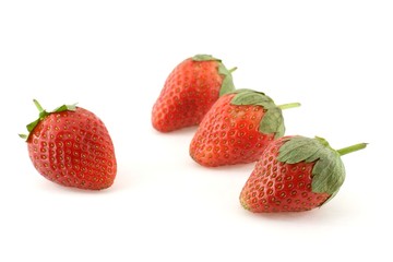 Four strawberries over white background