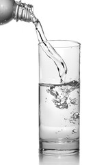 water pouring into glass from bottle isolated on white