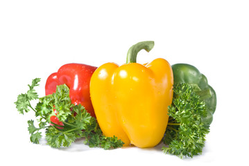 red, yellow and green pepper with parsley isolated on white