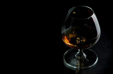 Cognac in the big glass on a dark background