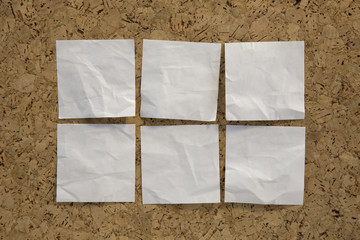 six blank white reminder notes on cork board