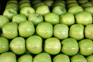 A pile of green apples at a farmers market