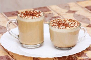 two cups of capuccino on white plate