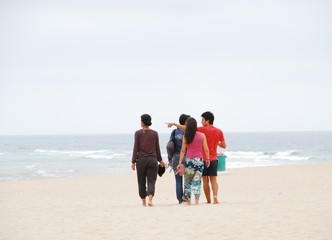 Beautiful family walking on beach