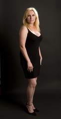 glamorous middle age woman posing in black dress