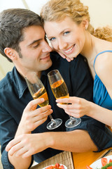 Young couple celebrating with champagne at home