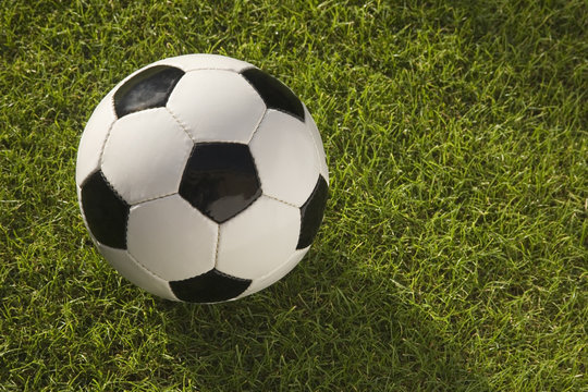 Close up of a Black and white leather Football on grass