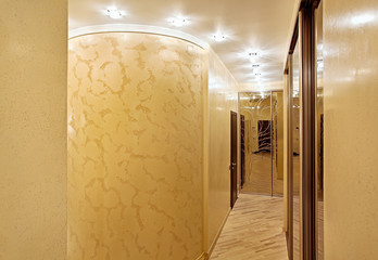 Passage with a mirror wardrobe and column in warm tones