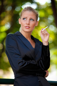 Young business woman smoking cigarette