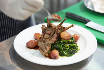 Chef is decorating grilled rack of lamb