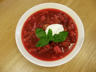 Bowl of borsch (beetroot soup) with sour cream and basil