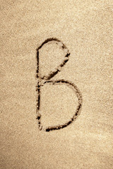 Alphabet letter B handwritten in sand