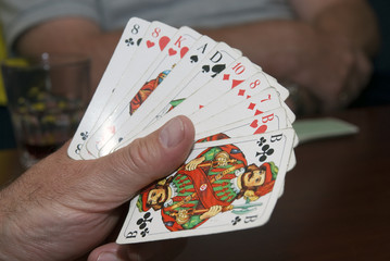 Hand hält ein Skatblatt