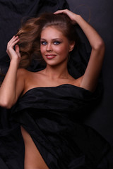 Naklejka premium beautiful woman lies on black, the top view