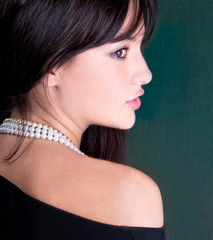 Beautiful woman with white pearl  looking back