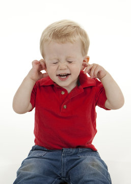 Young Boy Plugging His Ears And Closing His Eyes