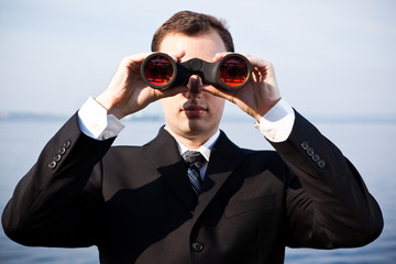 Caucasian businessman with binoculars